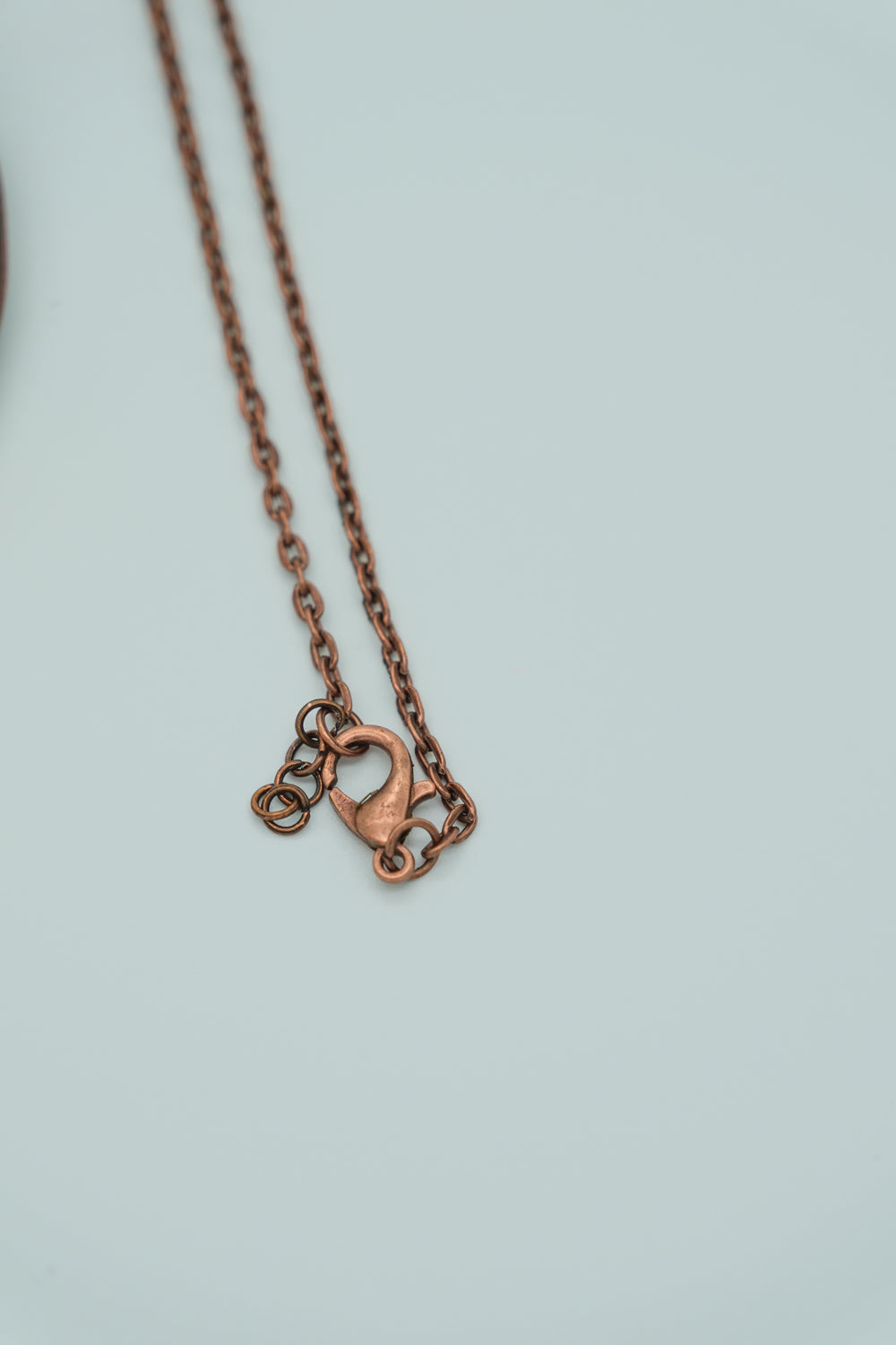 Copper necklace with a clasp on a light gray background