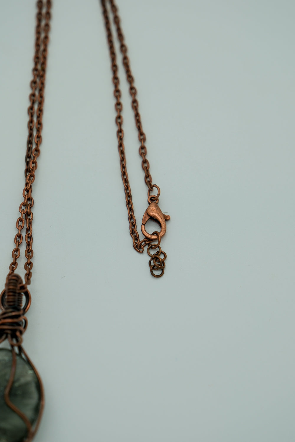 Necklace clasp with a pendant on a light gray background