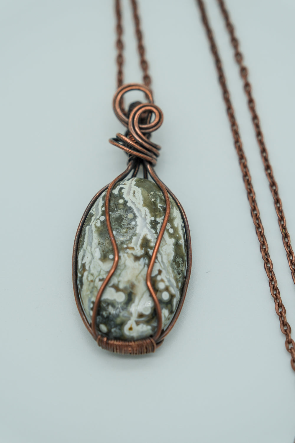 Necklace with a pendant featuring a natural stone design on a light gray background