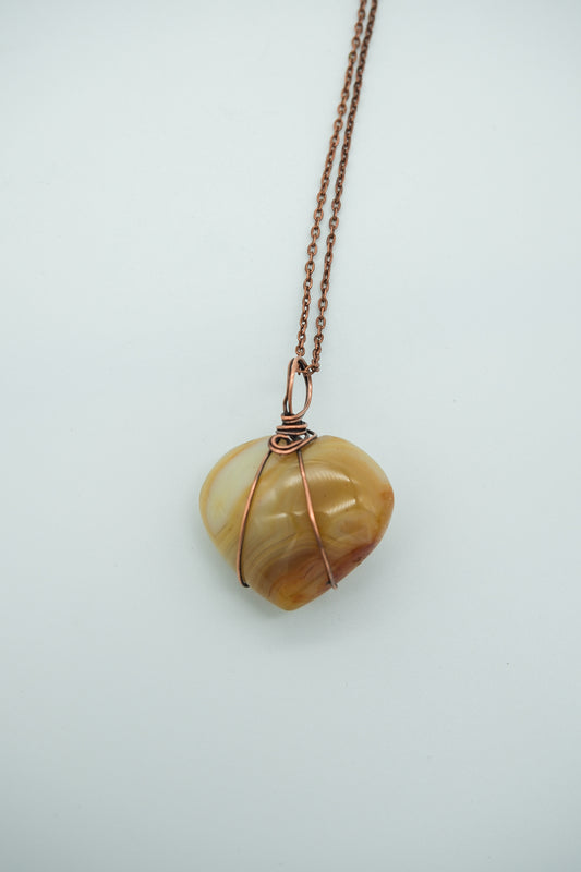 Necklace with a heart-shaped stone pendant on a light gray background