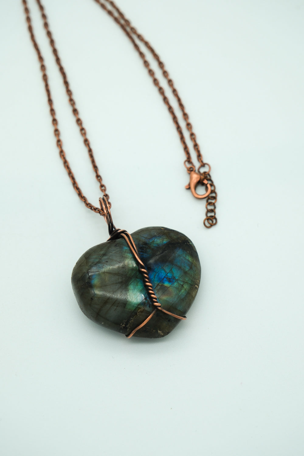 Necklace with a heart-shaped labradorite pendant on a light background