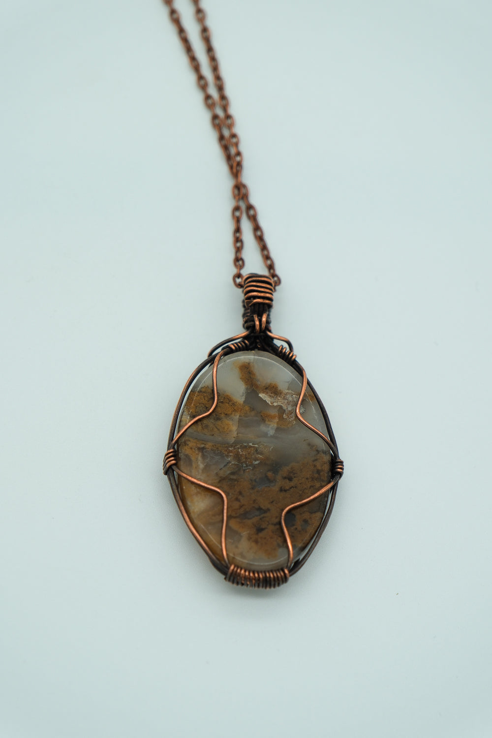 Necklace with a stone pendant on a light gray background