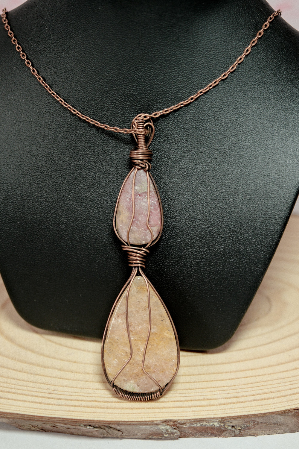 Necklace with a pendant featuring natural stones on a black and wooden background