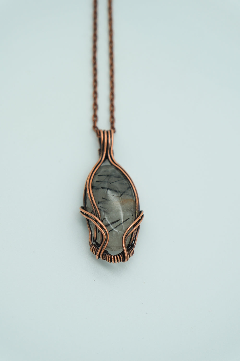 Necklace with a pendant featuring a stone on a light blue background