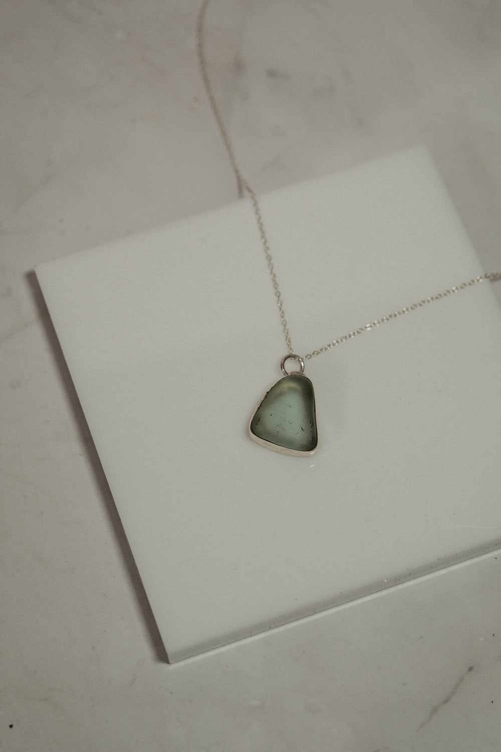 Necklace with a blue pendant on a white card