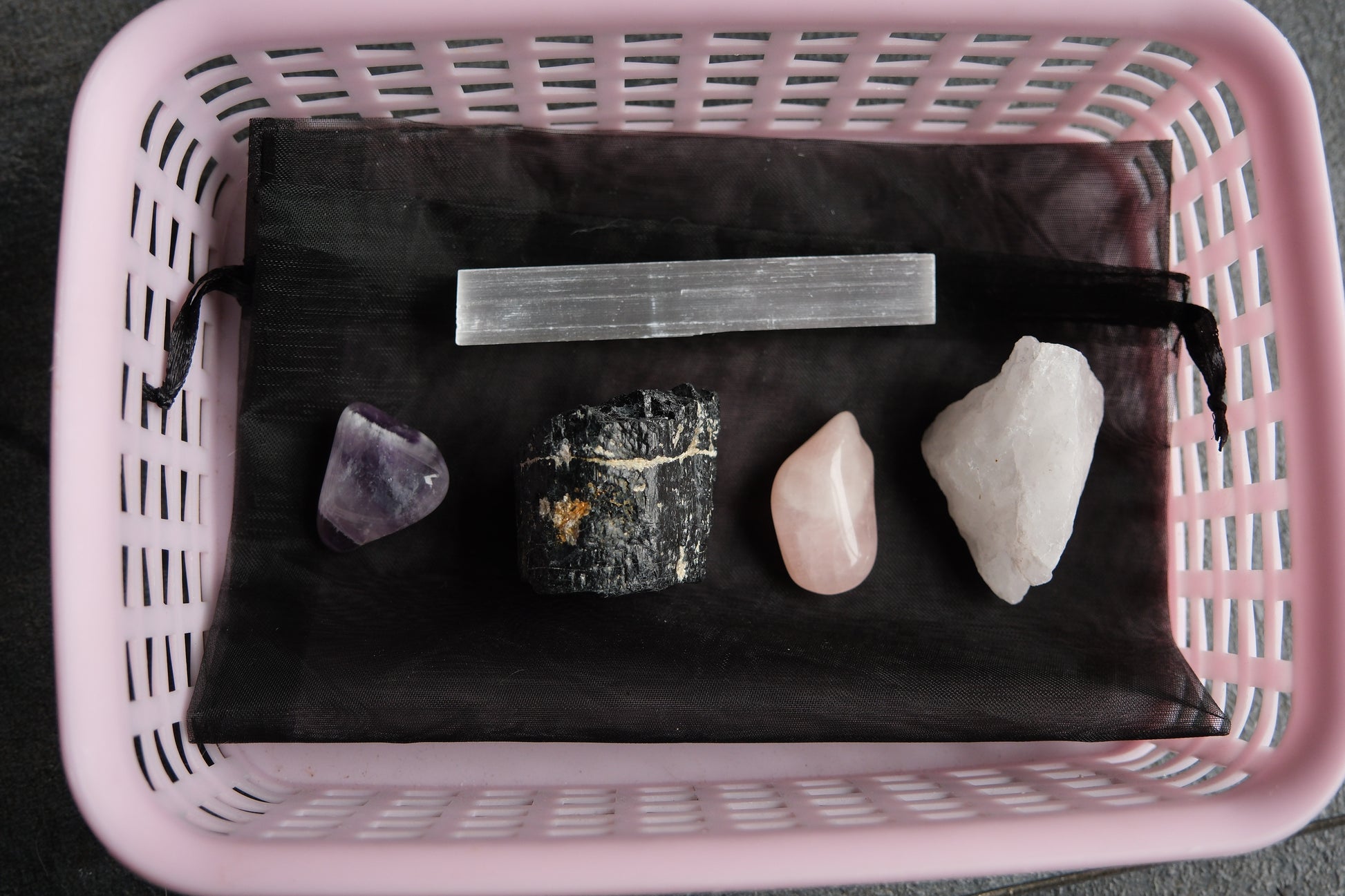 Pink basket containing various stones 