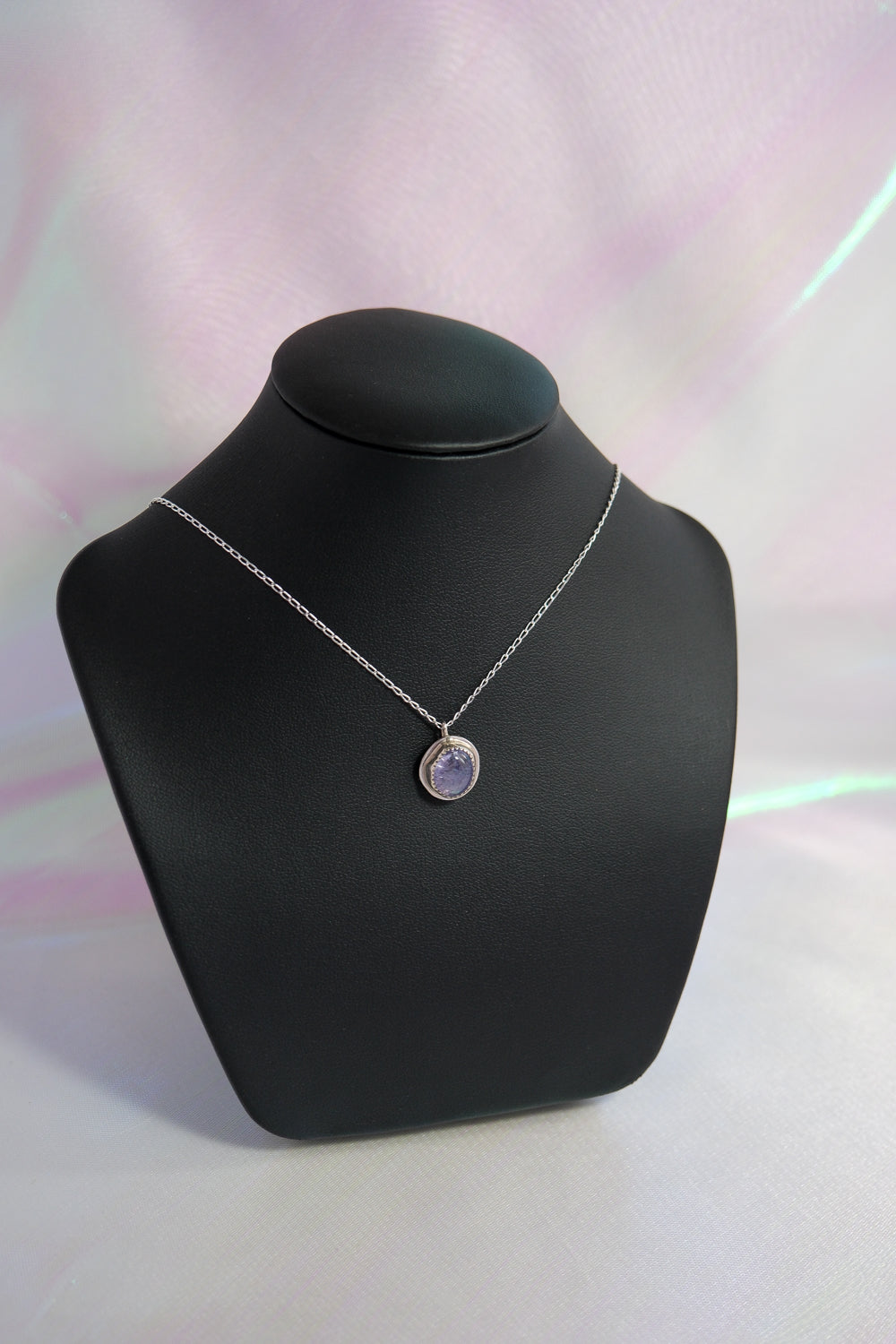 Necklace with a pendant on a black mannequin bust against a light background