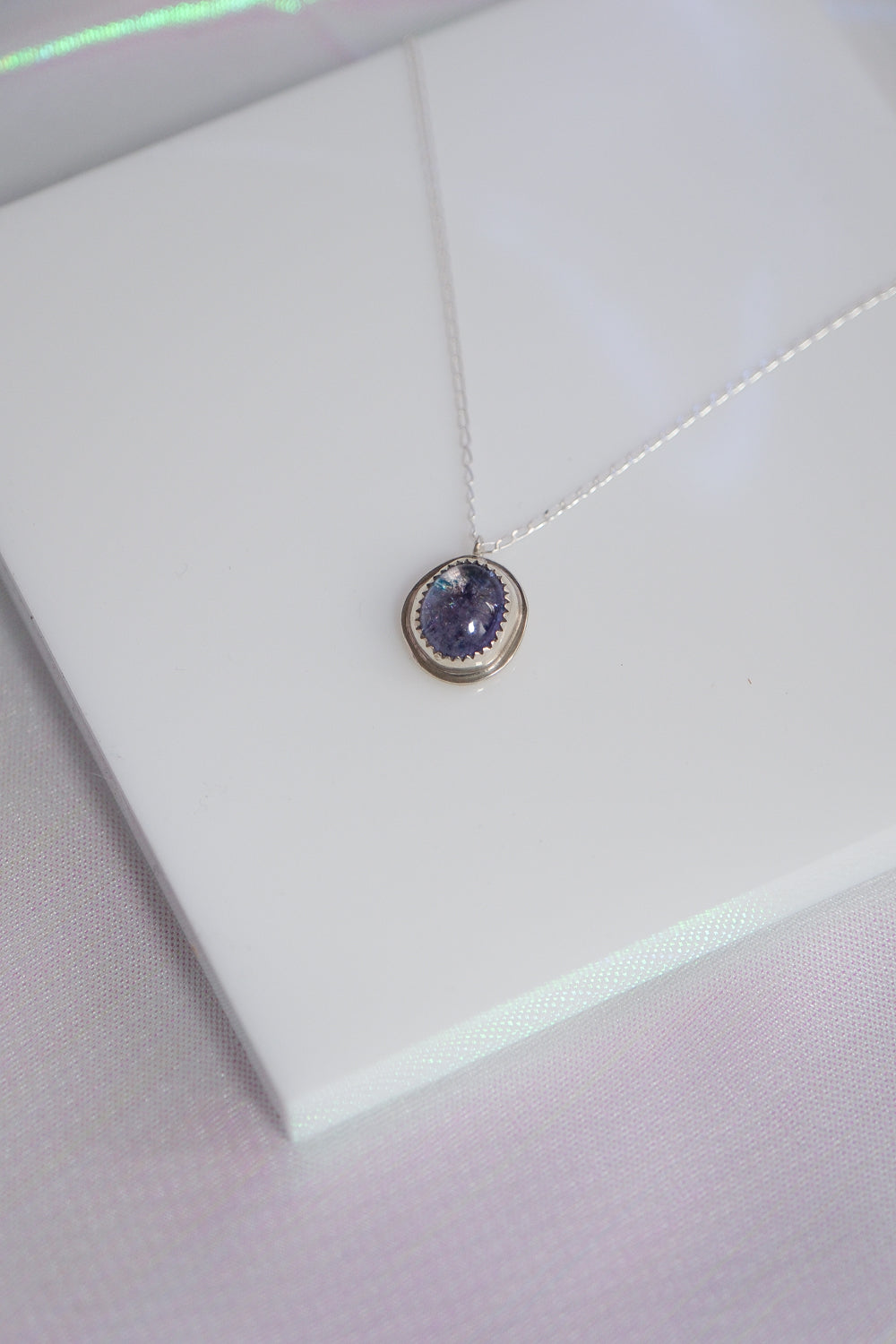 Necklace with a purple pendant on a white background