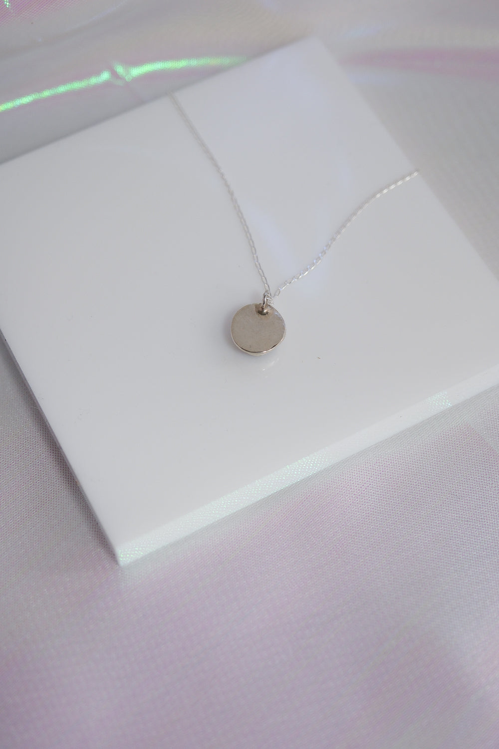 Necklace with a round pendant on a white card