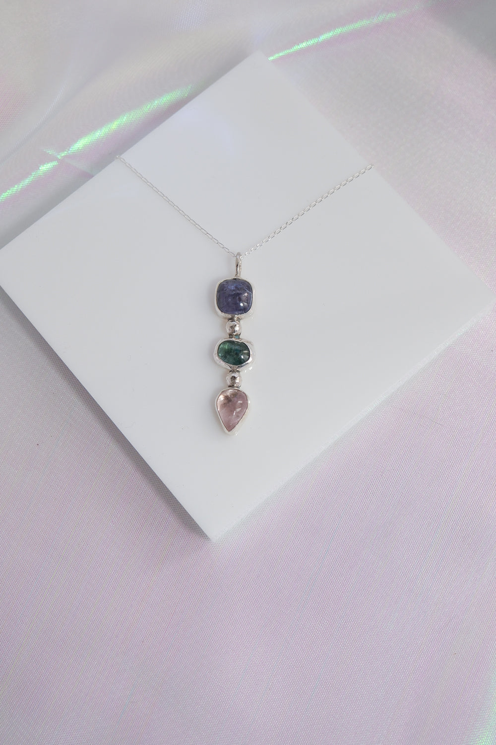 Necklace with three gemstones on a white card