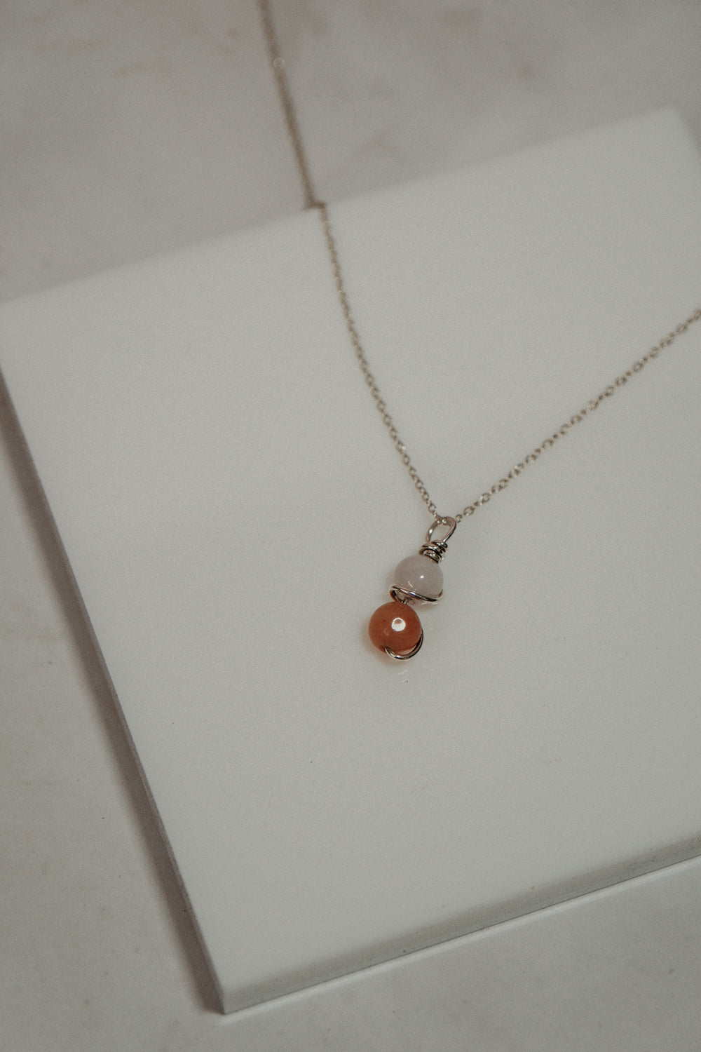 Necklace with two beads on a white surface
