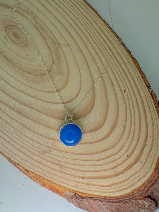 Blue pendant necklace on a wooden surface