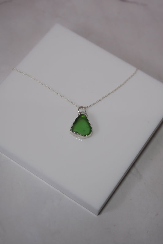 Green pendant necklace on a white box