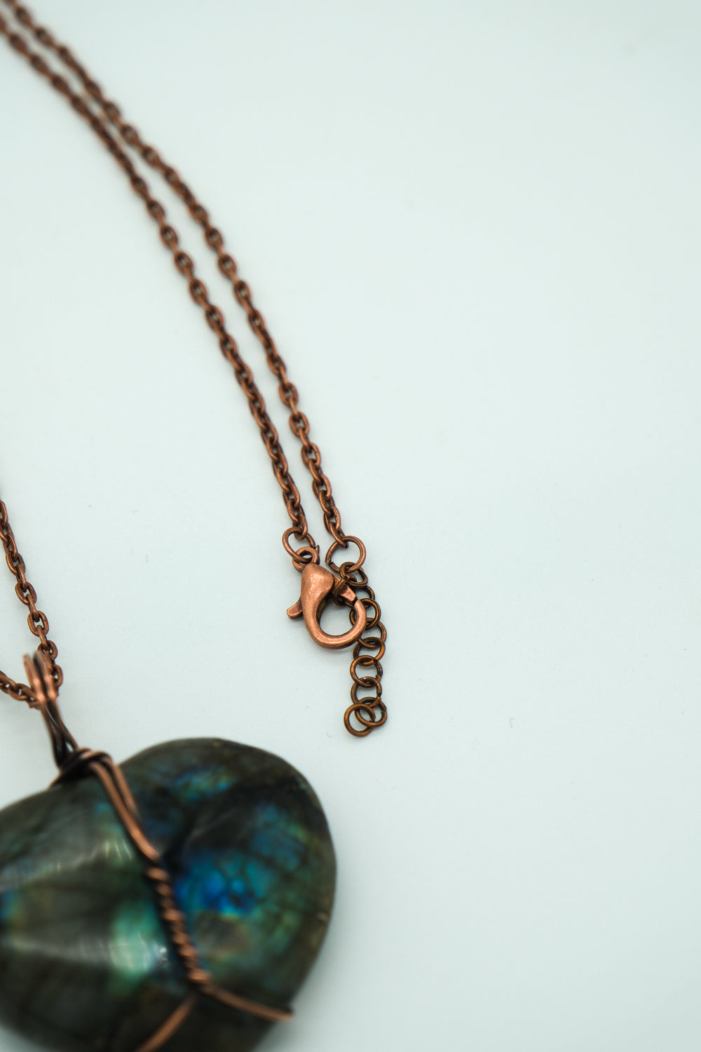 Necklace with a heart-shaped labradorite pendant on a light background