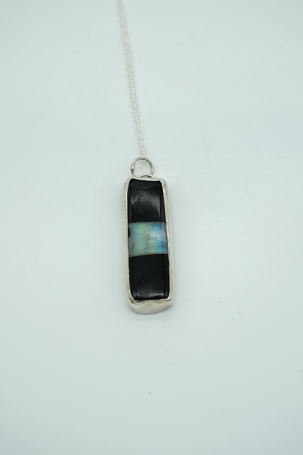 Necklace with a pendant featuring black and blue colors on a white background