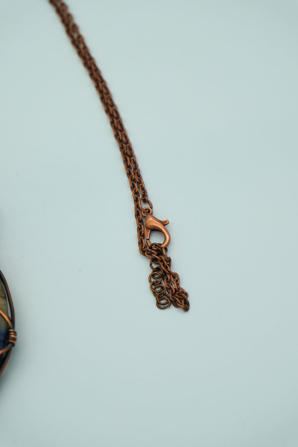 Copper chain necklace on a light blue background
