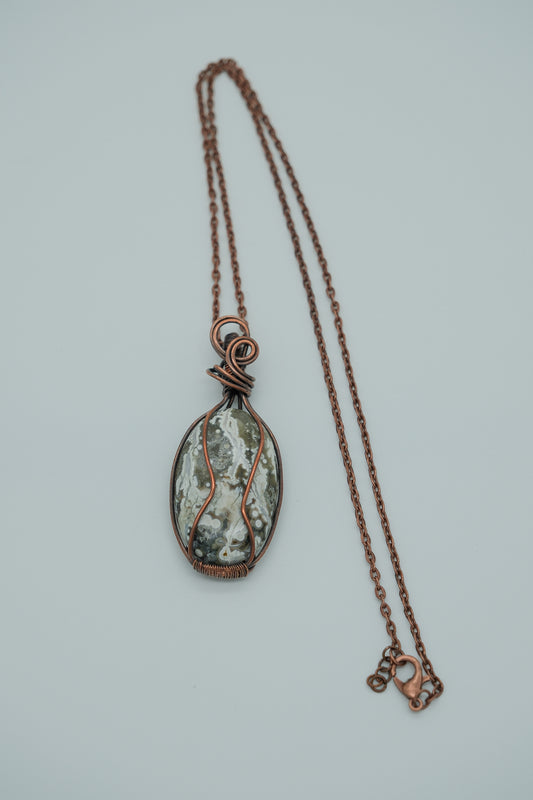 Necklace with a pendant featuring a natural stone design on a light gray background