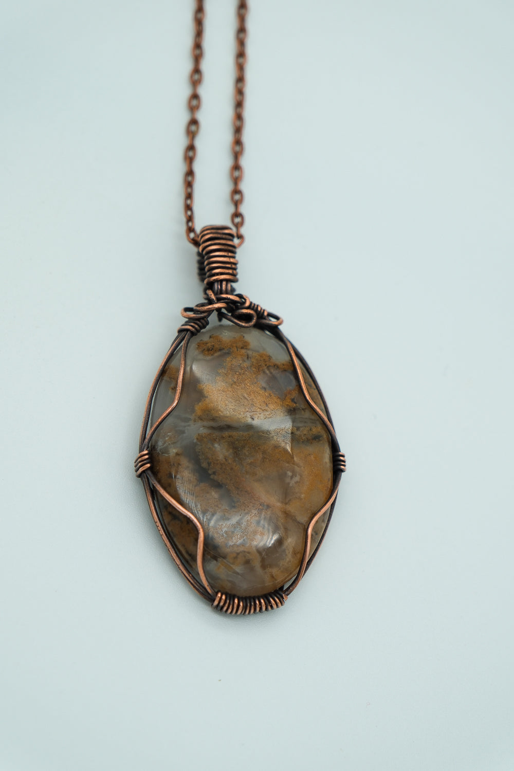 Necklace with a stone pendant on a light blue background