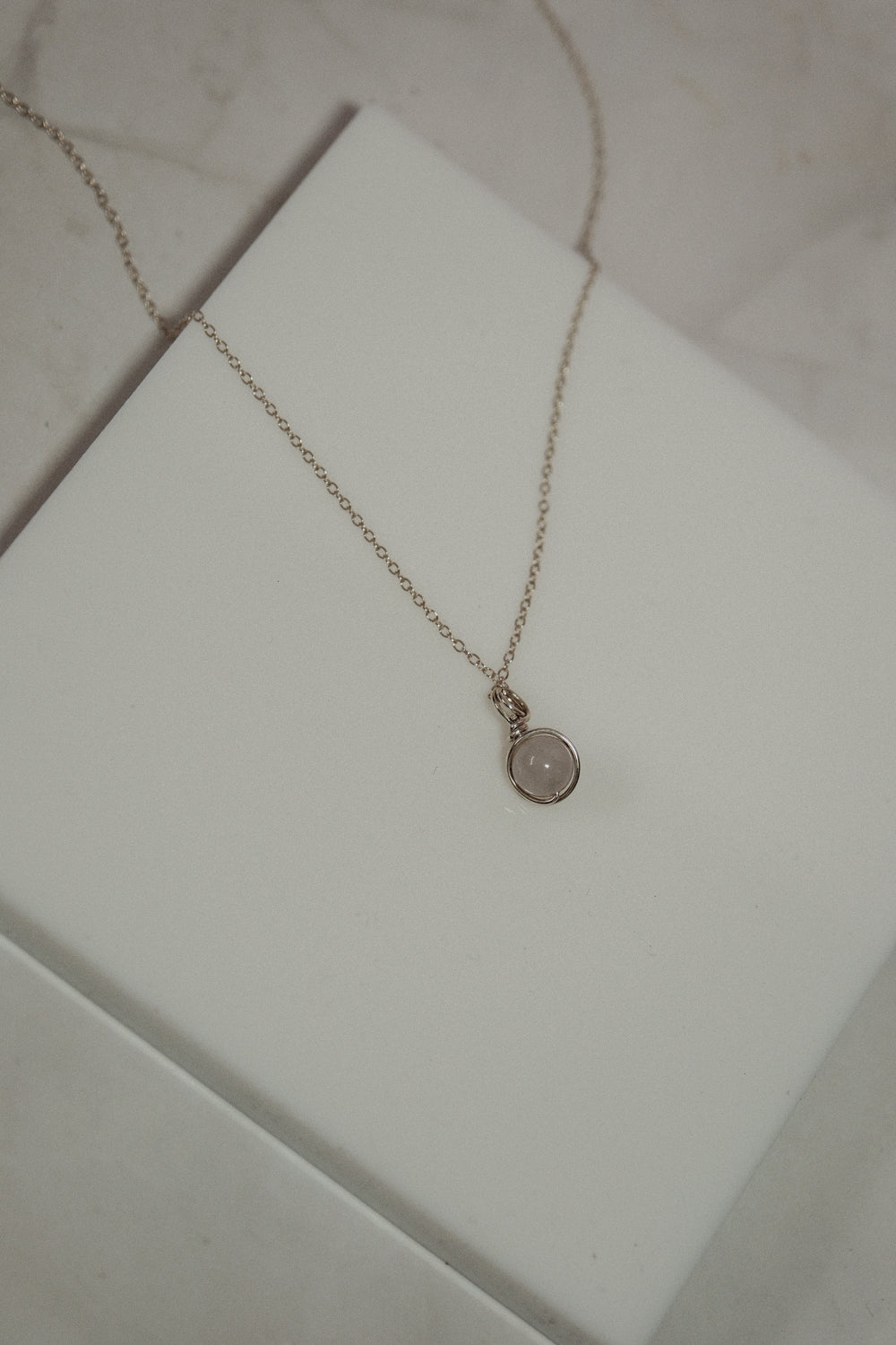 Necklace with a round pendant on a white surface