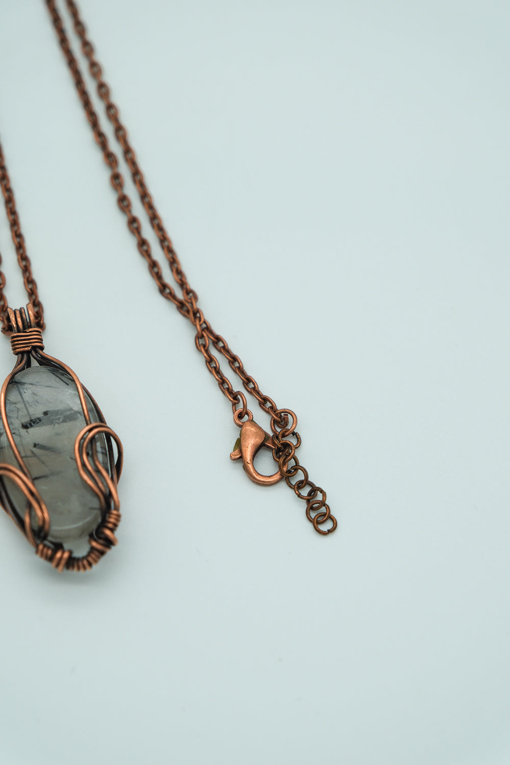Copper necklace with a pendant on a light blue background