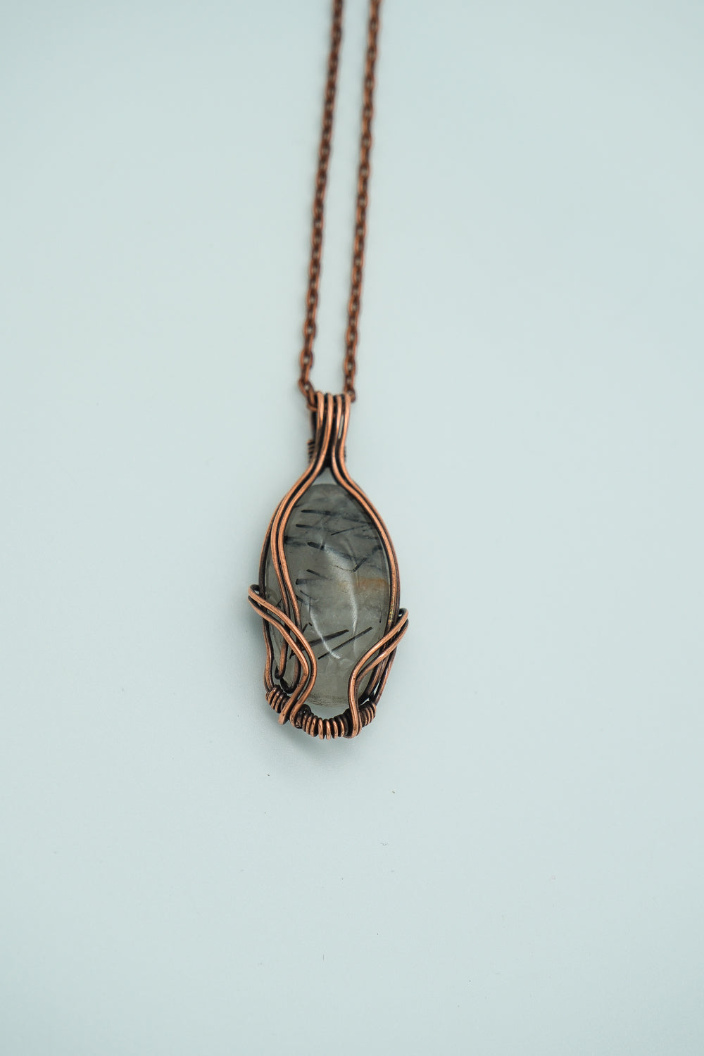 Necklace with a pendant featuring a natural stone design on a light blue background