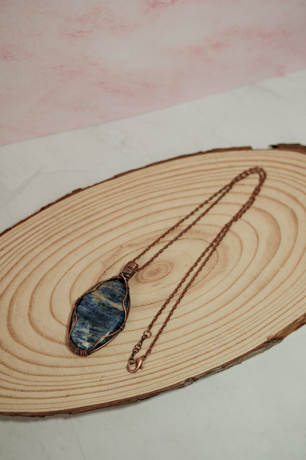 Necklace with a blue stone pendant on a wooden surface