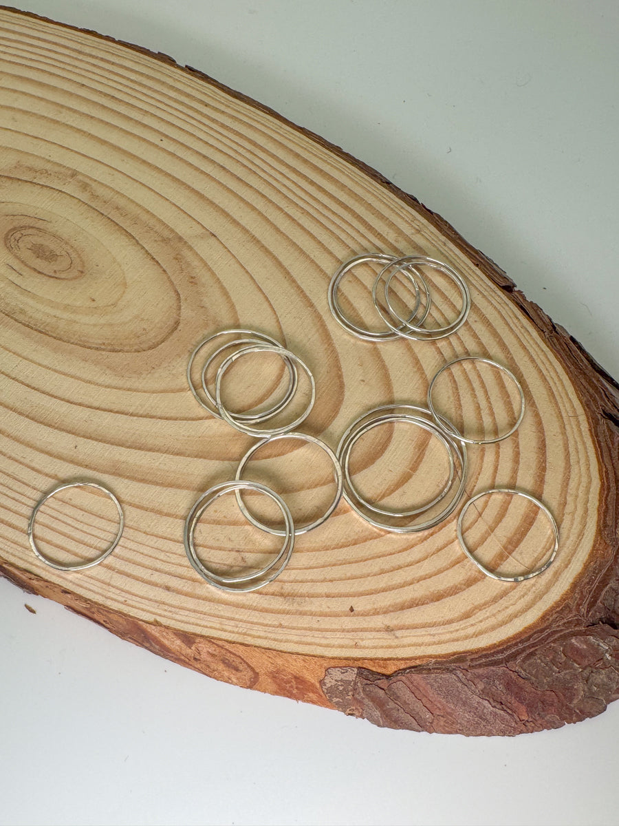 Sterling silver rings on wooden log